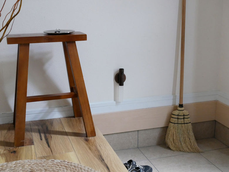 木材とラミネート床の上に置かれたほうきとモップなどの家庭用掃除用品