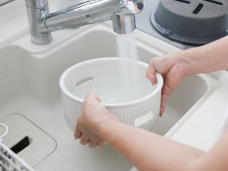 サリューの美濃焼炭焼き水コンロが設置された清潔なキッチンシンクとプラスチック製の蛇口が備わった家庭用アプライアンス