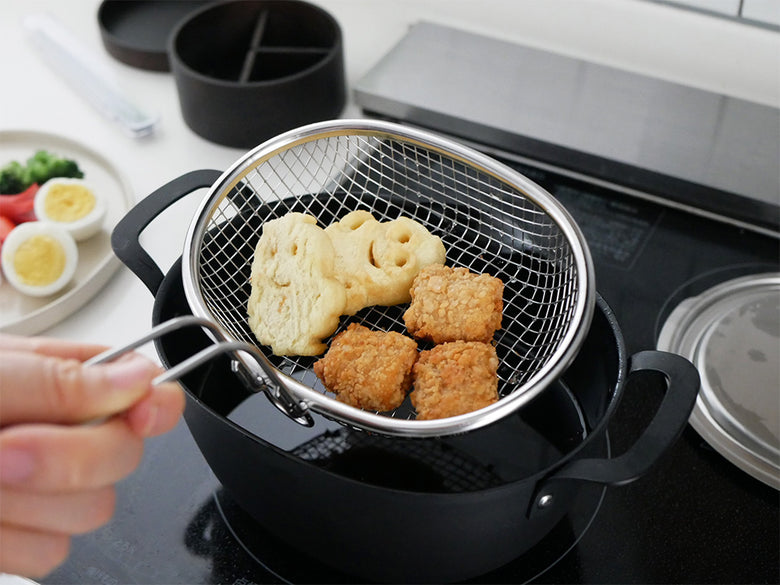 アイカタの楕円形鉄製揚げ鍋で揚げ物を調理している様子