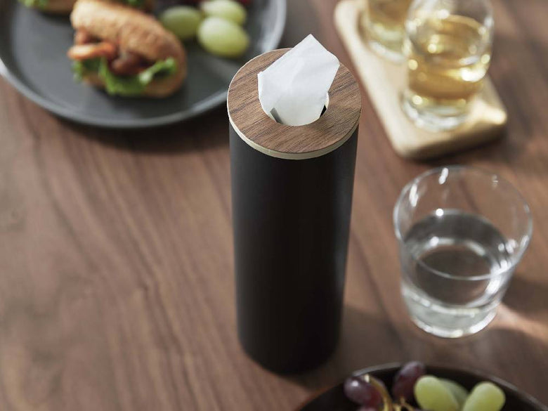スチールと天然木を使用した【RIN/リン】ボトル型ティッシュケース Sがテーブル上に置かれており、蓋が開いてティッシュが見えている