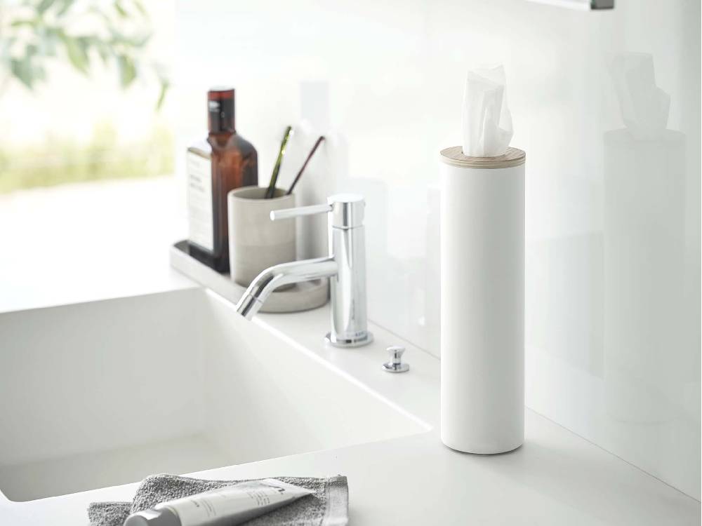 バスルームの洗面台に置かれたスチールと天然木のボトル型ティッシュケース『RIN/リン』