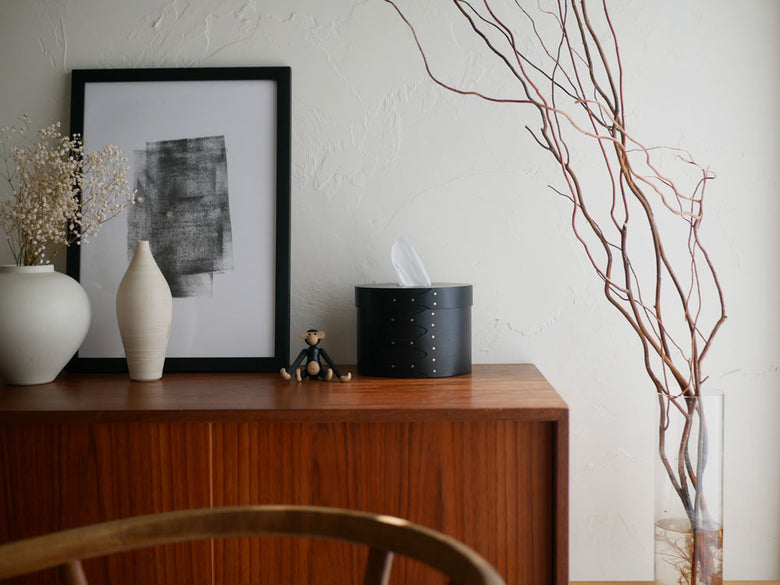 チェリー材製のアクシスシェーカーティッシュボックスが室内の家具として花瓶や観葉植物と共に美しく配置されている様子