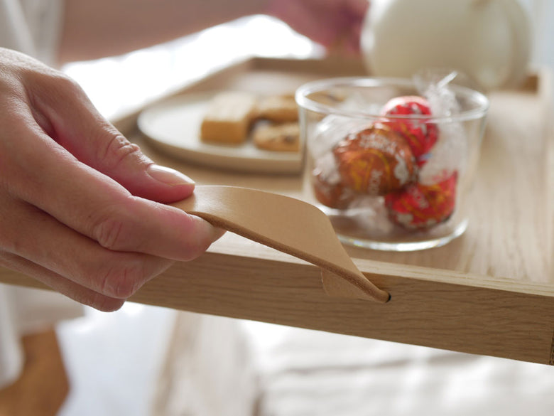 フリッツ・ハンセンのSkagerak Norr Tray。オークとレザー製のトレイ上に食器やカトラリー、調理器具が美しく配置されています