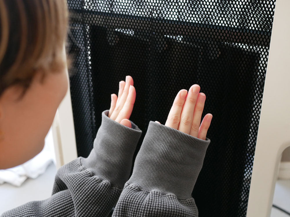 シロカの遠赤外線軽量ヒーター「かるポカ」のそばで立つ靴下を履いた子供