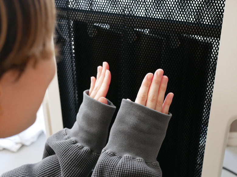 シロカの遠赤外線軽量ヒーター「かるポカ」のそばで立つ靴下を履いた子供