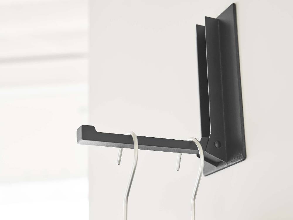 ホワイトのマグネット折り畳みハンガーがスチール製の棚に取り付けられている様子