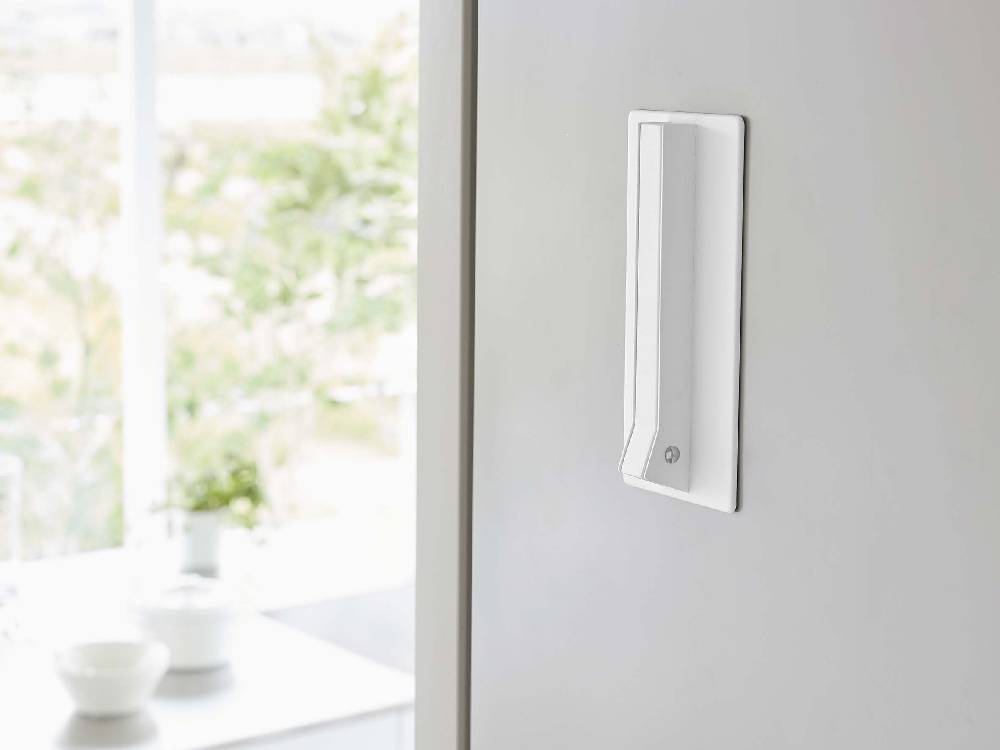 ホワイトカラーのマグネット式折りたたみハンガーが壁面に取り付けられている様子