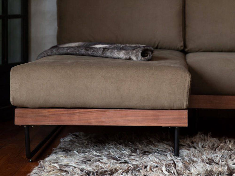 ウォルナット木製のブラウンウェルメカウチソファが配置された快適なリビングルームのインテリア