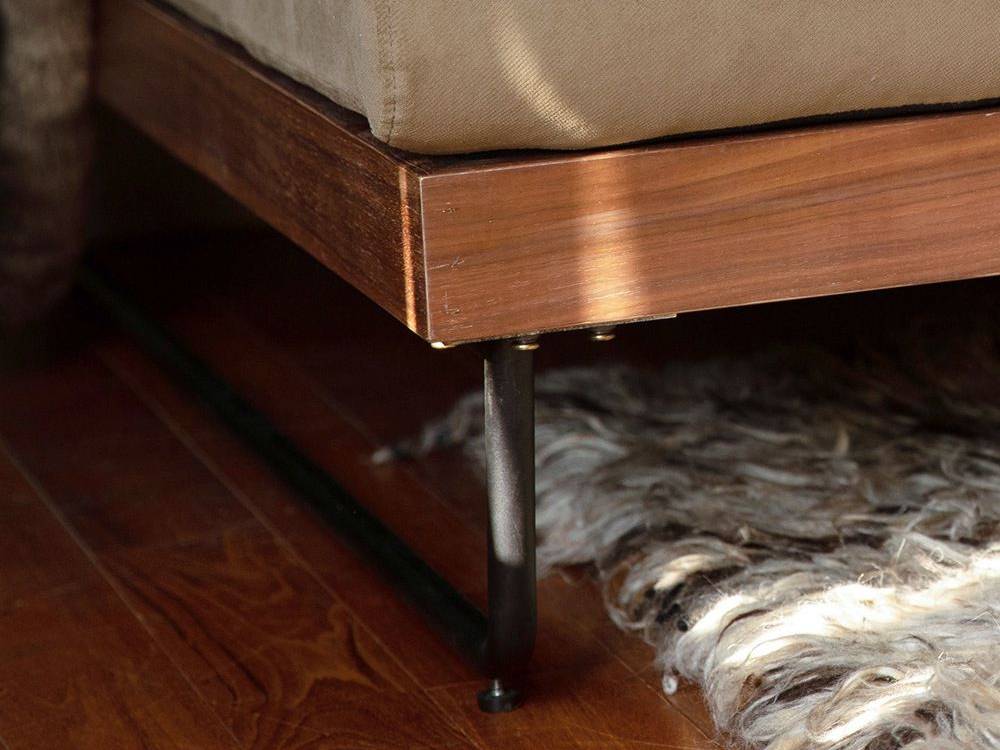 ウォルナット材とアイアン脚を使用したブラウン色のウェルメカウチソファが配置されたベッドルーム