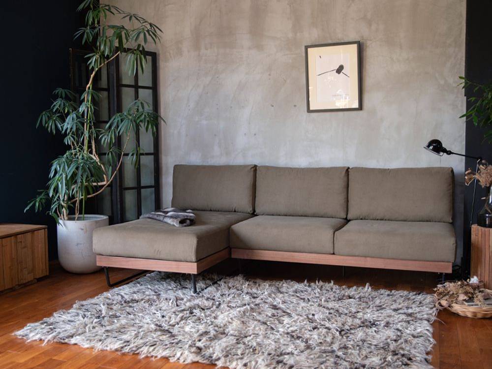 ハードウッドの床に配置されたブラウンのアデペシュウェルメカウチソファを備えた居心地の良いリビングルームのインテリア