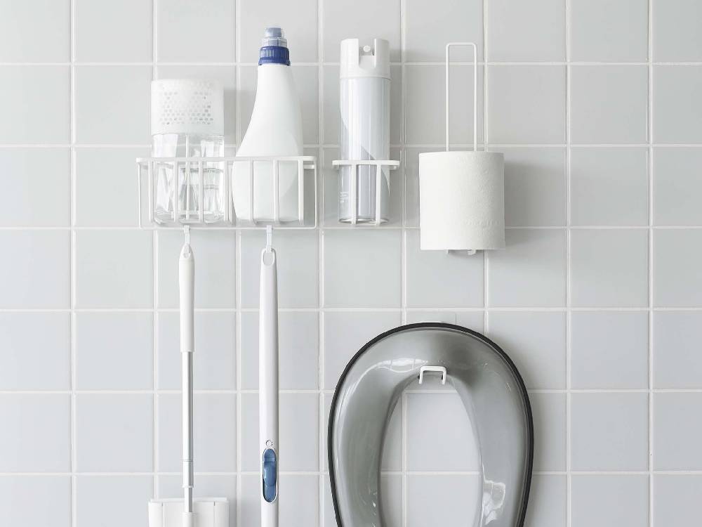 シルバー仕上げの【tower/タワー】フィルムフックトイレットペーパーホルダーがバスルームの壁に取り付けられている様子。スチール製でシンプルなデザイン。