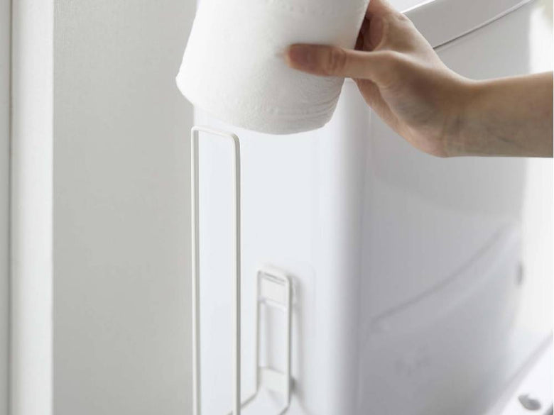 towerフィルムフックトイレットペーパーホルダーが白いバスルームに設置され、トイレットペーパーが掛けられている様子