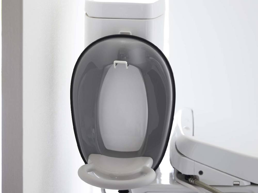 タワーのフィルムフックトイレ用品収納フックが白いトイレに取り付けられているバスルームの様子