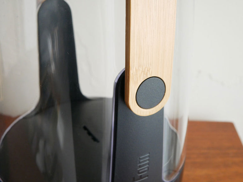 スタドラフォームのアロマディフューザーSOPHIE。炎がゆらめく円筒型デザインがワインボトルと共に静物写真として撮影されています。