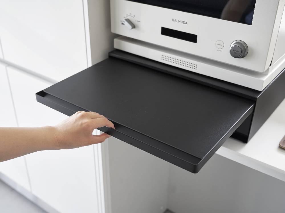 ホワイトのタワー型キッチン棚に家電下引き出しとスライドテーブルが組み込まれたモダンなデザイン。