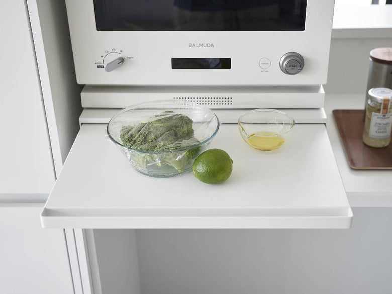 タワー型のホワイトまたはブラックキッチンキャビネットで、下引き出しとスライドテーブルが備わったツーウェイ家電ユニット