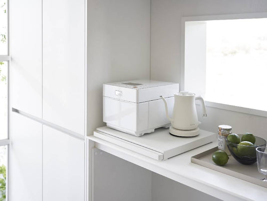 キッチンキャビネット下に設置されたシルバーのタワー型キッチン家電用スライドテーブル。スチールとプラスチック製の棚が収納スペースを提供しています。