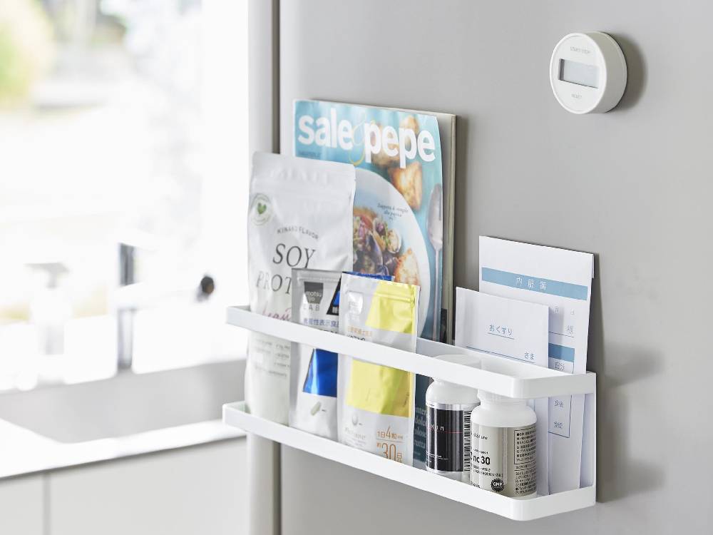 スチール製マグネット冷蔵庫横ラックが壁に設置され、調味料瓶とサプリメントが整然と並べられている様子