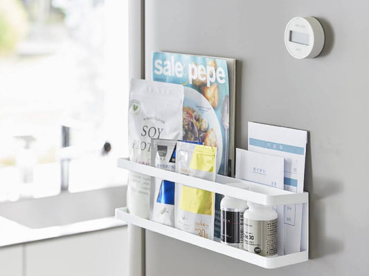 スチール製マグネット冷蔵庫横ラックが壁に設置され、調味料瓶とサプリメントが整然と並べられている様子