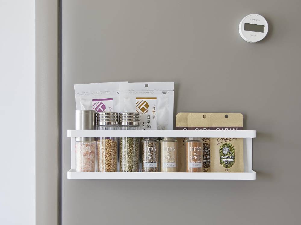 スチール製のタワーマグネット冷蔵庫横サプリ＆調味料ラックが平らな壁面に取り付けられ、2つのフックが掛けられている様子