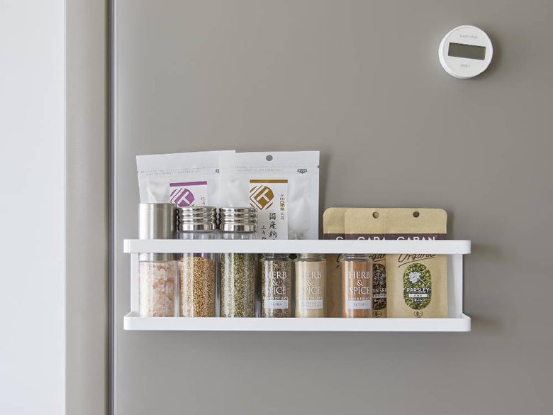 スチール製のタワーマグネット冷蔵庫横サプリ＆調味料ラックが平らな壁面に取り付けられ、2つのフックが掛けられている様子