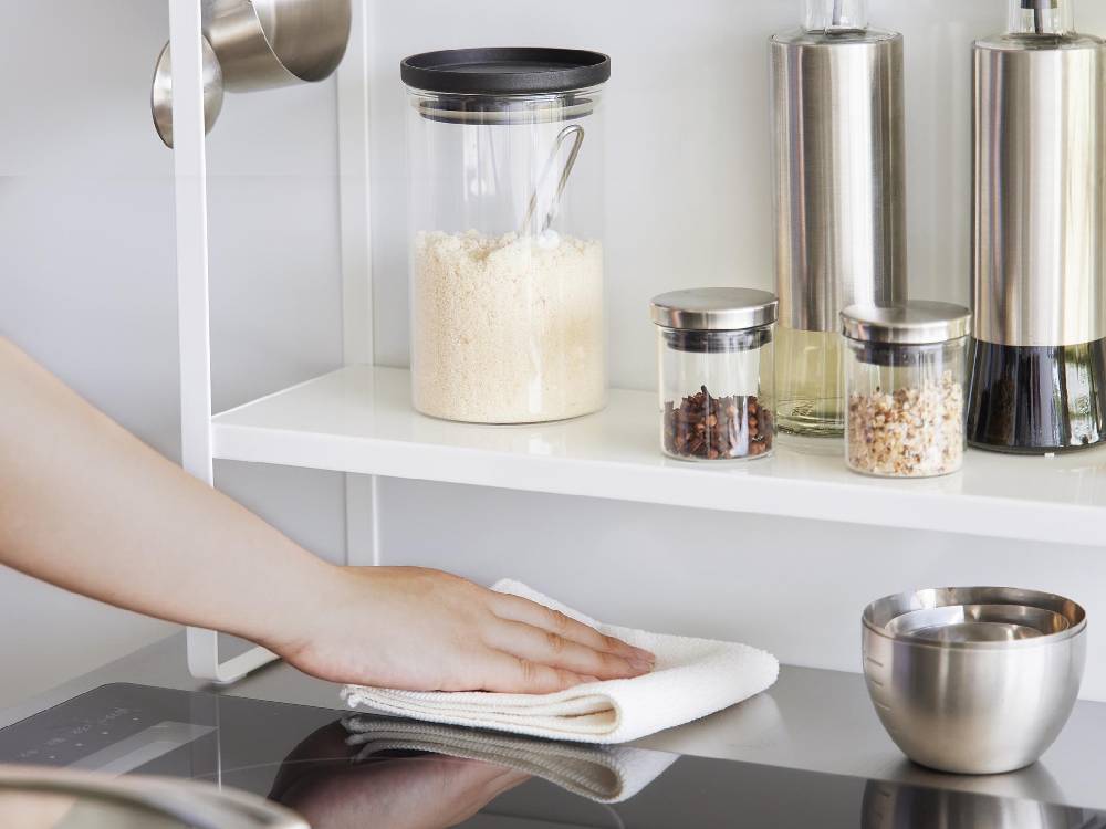 タワー下拭けるコンロ横ラック2段、スチール製のキッチンシェルフに食器や調理器具が整理されている様子