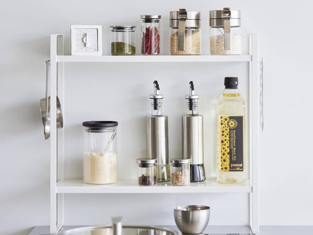 キッチンに設置されたスチール製タワーコンロ横ラック2段。上段と下段に瓶や食器が整然と収納されている