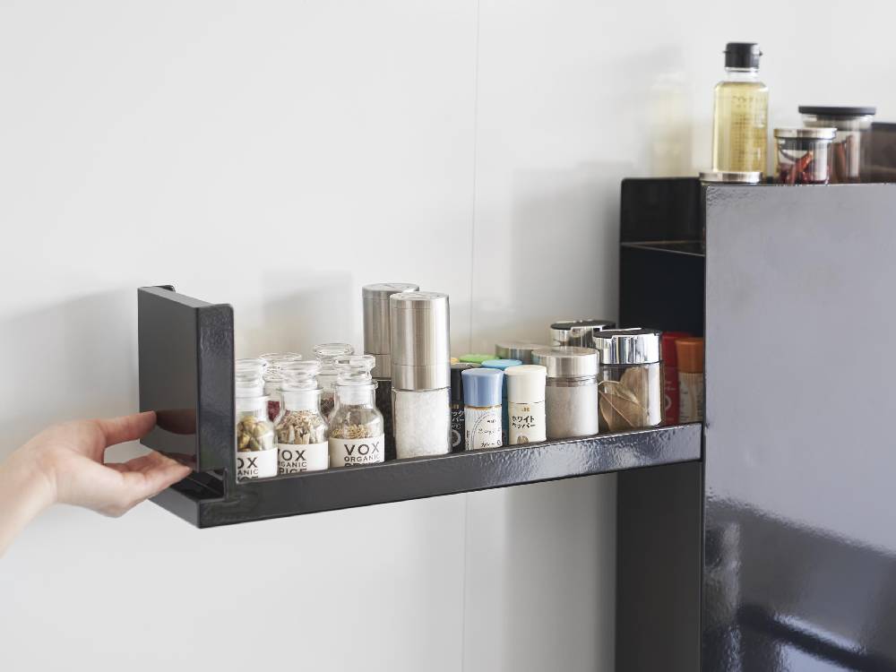 スチール製の2段調味料ラックに調味料ボトルが整然と並べられたキッチンの棚