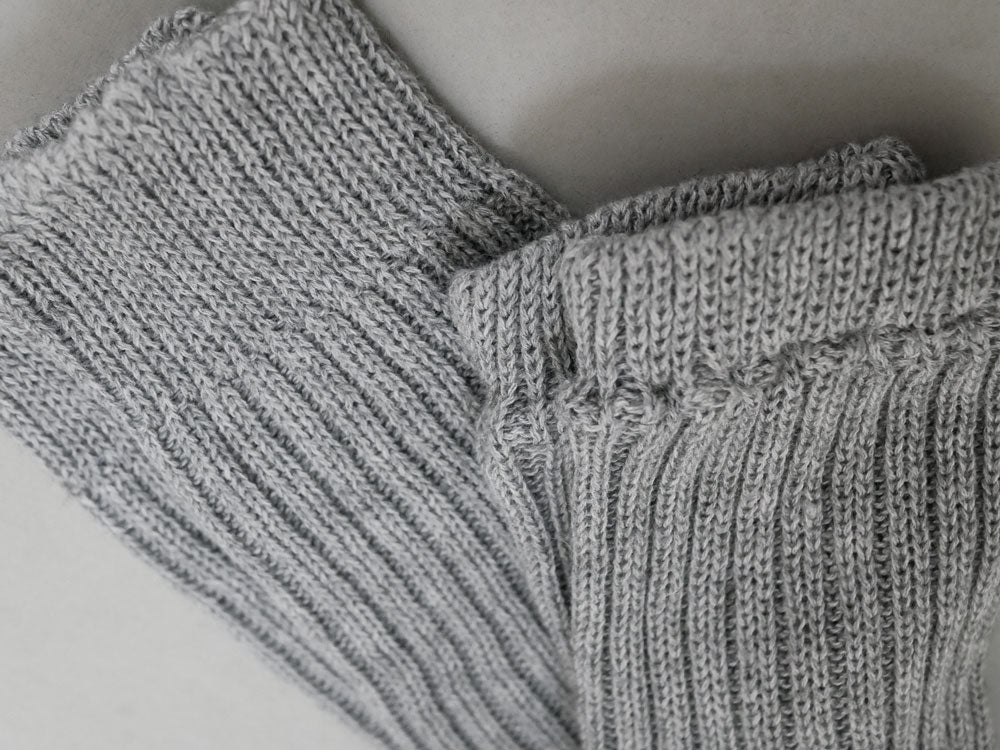 メメリのカシミヤコットン製アーム＆レッグウォーマー。白と灰色の柔らかいウール素材で編まれたニットアクセサリー。