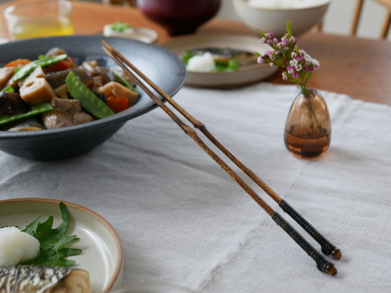 黒竹取り箸とスプーン、ボウル、皿が整然と並んだ上品な食卓セッティング