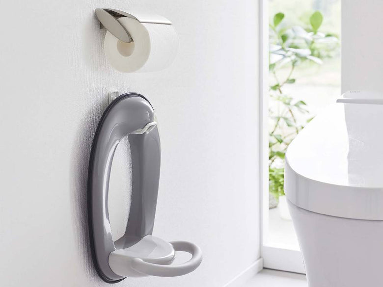 白いトイレの壁に取り付けられたタワーウォールトイレ用品収納フック。銀色のトイレットペーパーホルダー付き