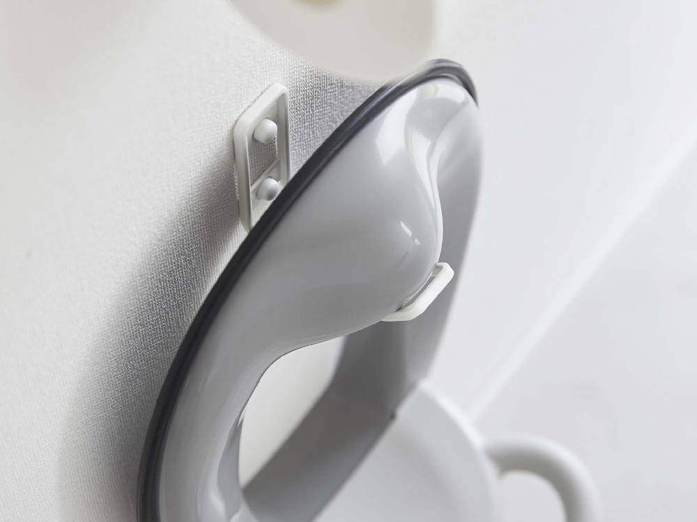 白色のトイレに取り付けられたタワーウォールトイレ用品収納フックとプラスチック製便座