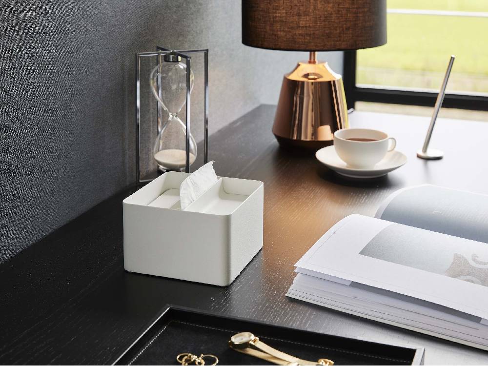 スチール製の銀色蓋付きハーフティッシュケース「tower/タワー」が花鉢とオフィス用品とともに机の上に配置されている様子