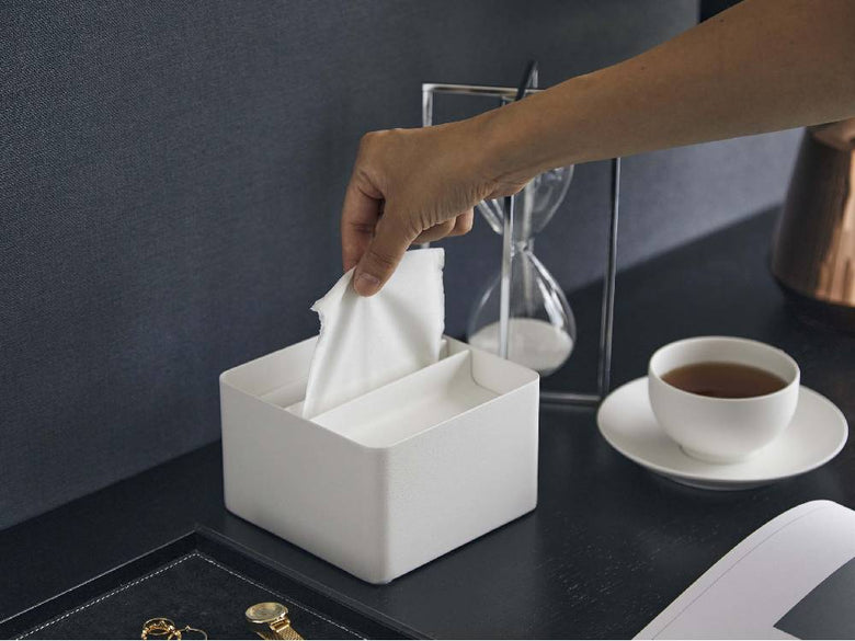 スチール製の蓋付きタワー型ハーフティッシュケースがテーブル上に置かれ、蓋が開かれてティッシュが見える様子