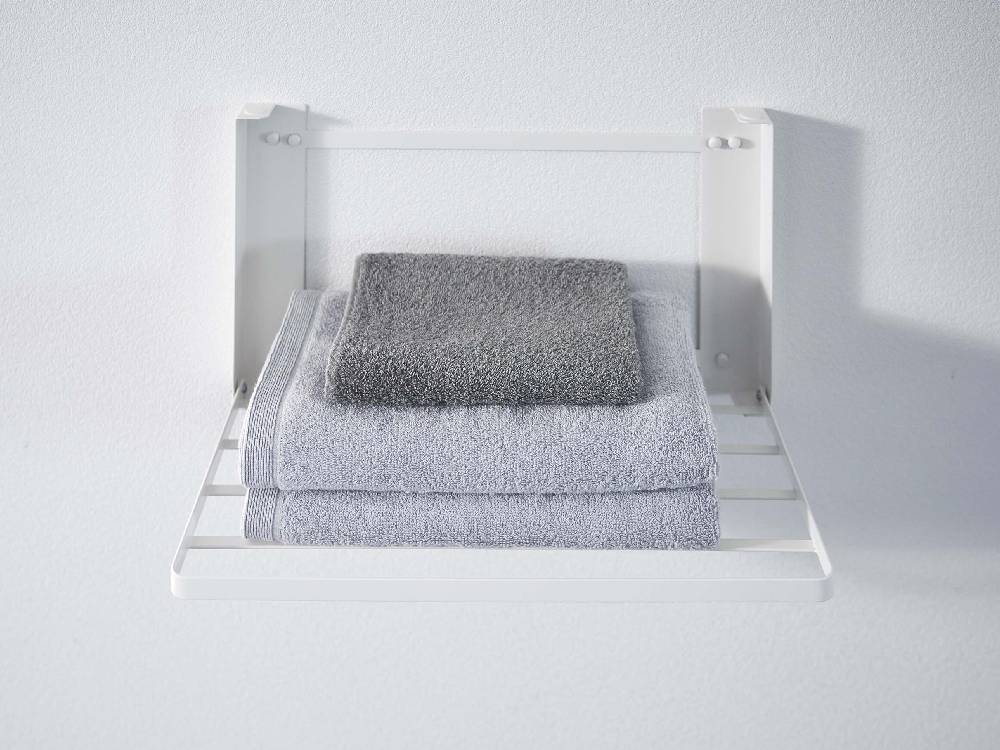 スチール製の折りたたみ棚にタオルが掛けられている様子