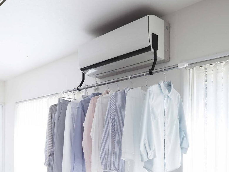エアコンに取り付けられたフィルムフック式室内物干しポールホルダー