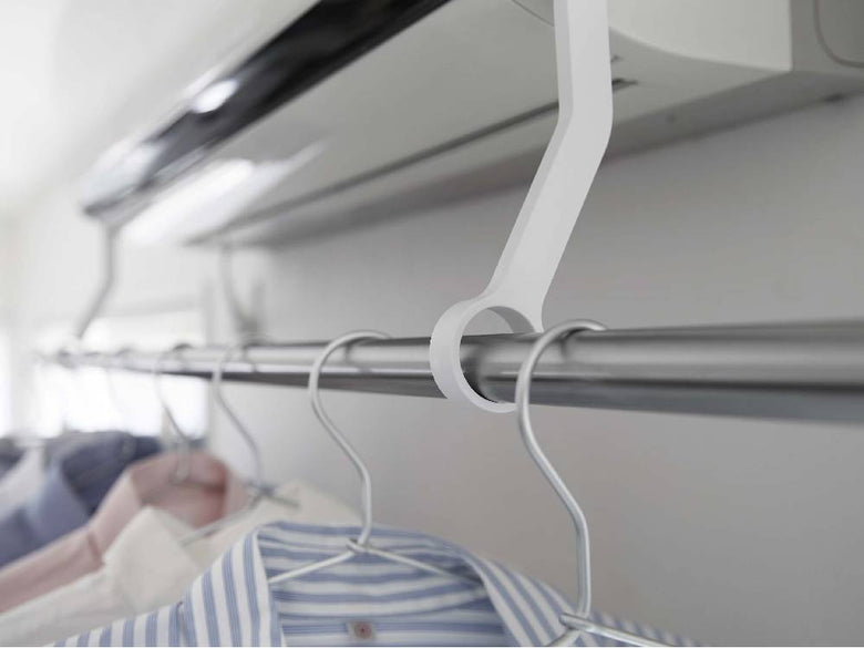 エアコンに取り付けられた【tower/タワー】フィルムフック物干しポールに掛かった洋服ハンガー