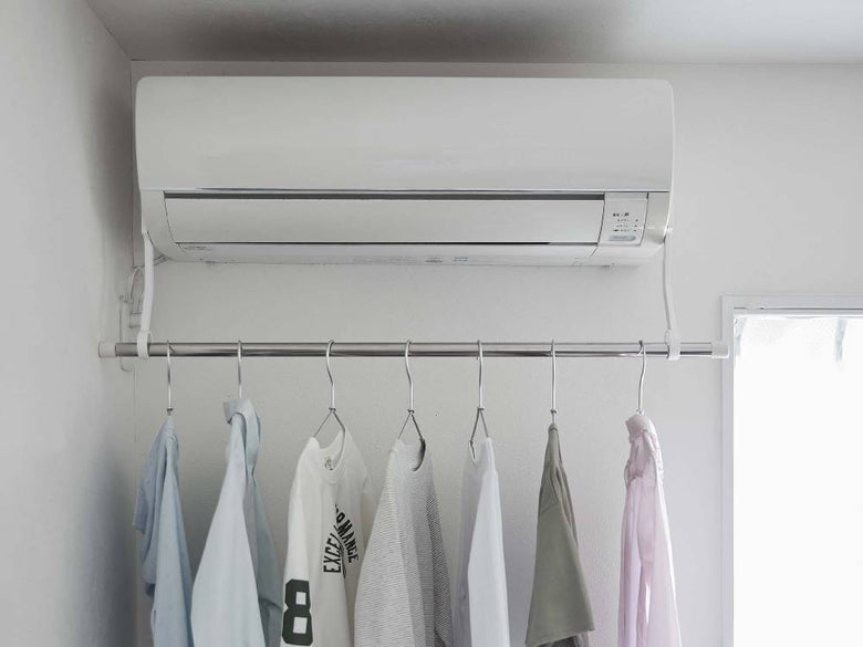 エアコンにフィルムフックで取り付けられた【tower/タワー】室内物干しポールホルダー