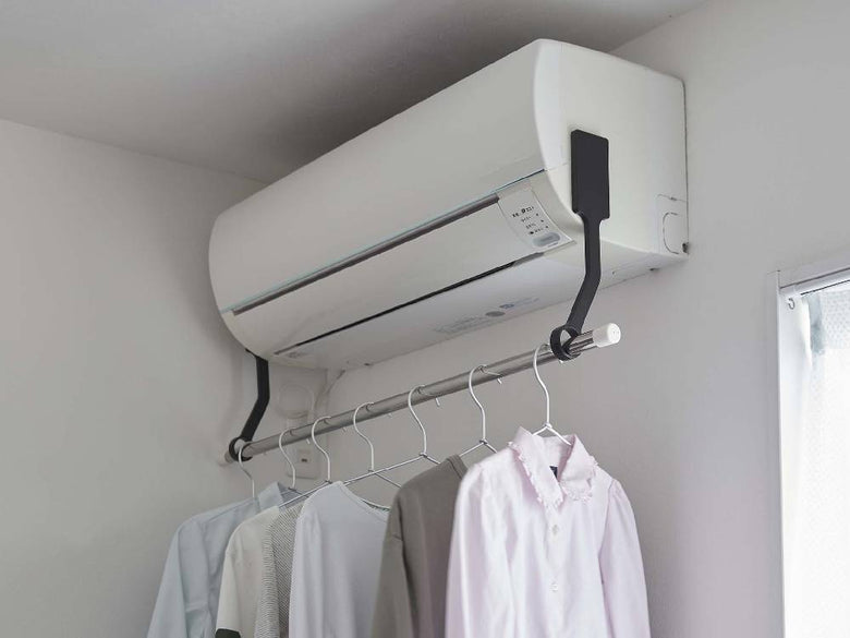 エアコン側面に取り付けられたフィルムフック室内物干しポールホルダーとポールに掛けられた洗濯物の様子