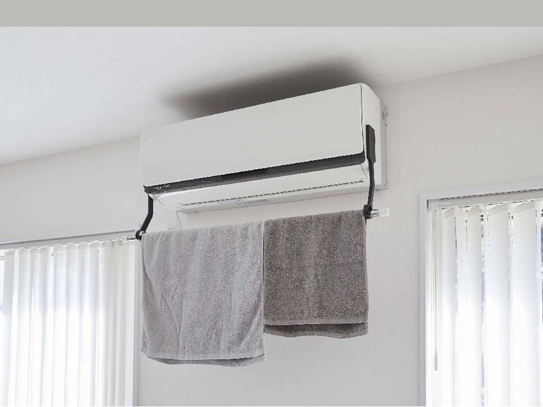 タワー型フィルムフックでエアコンに取り付けられた室内物干し用ポールホルダーの画像