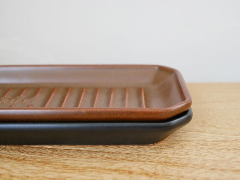 木材と耐熱陶器で仕上げられたバーニッシュサービングトレイに、整然と配置された食器が載っている写真