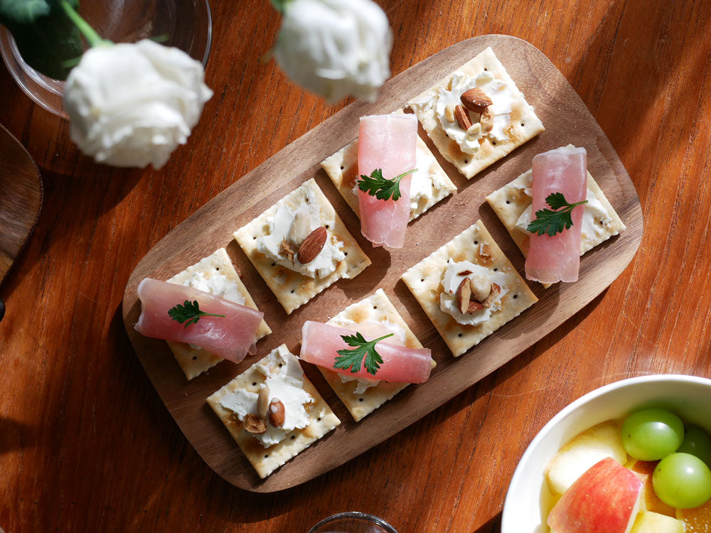 イーブキクラフトの耐熱陶器グリルプレートに、チーズやミート、クラッカーなどのフィンガーフードが美しく盛り付けられている様子