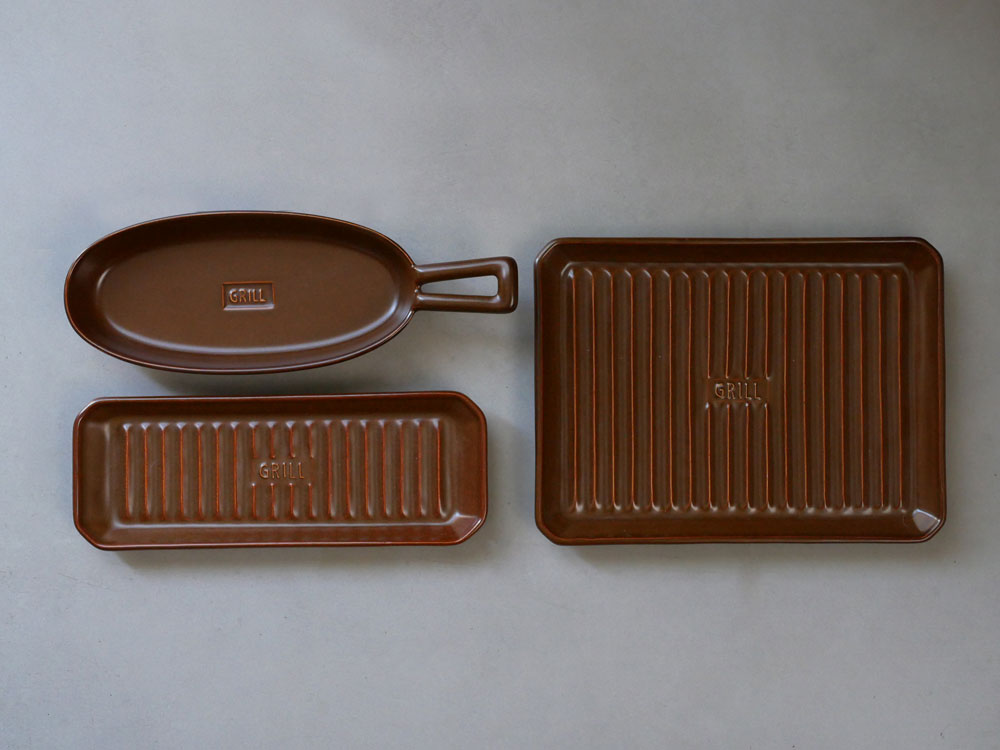 IBUKICRAFTの耐熱陶器製魚焼きグリルプレートとサーヴィングトレイ、食器類が並んだキッチン用品セットの写真