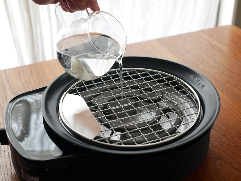 シロカの「おうちいろり」家庭用多機能調理器具ブラックモデル。深皿、ボールプレート、焼き網など多彩なプレートが付属しています