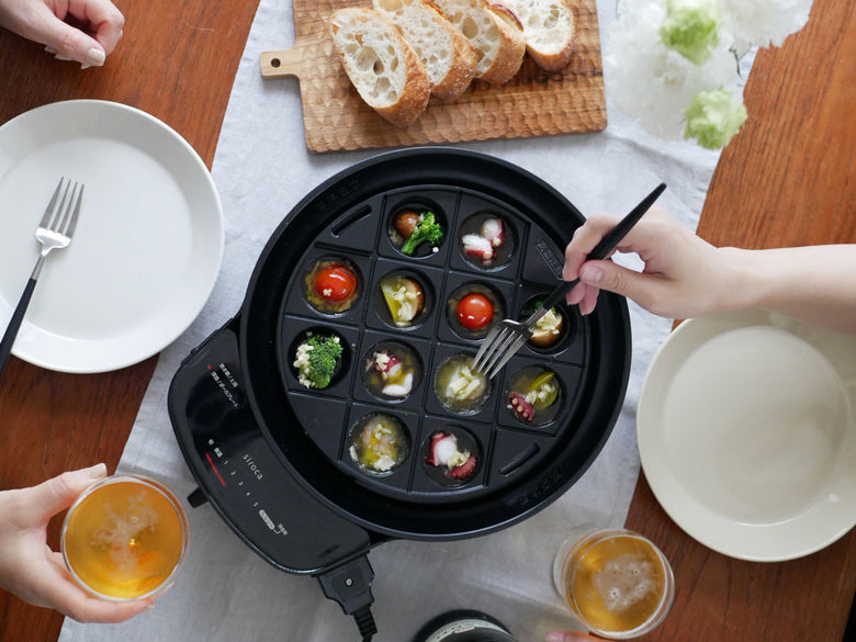 シロカの「おうちいろり」セットと多彩なプレート、テーブルウェア、食材が揃った家庭の調理風景