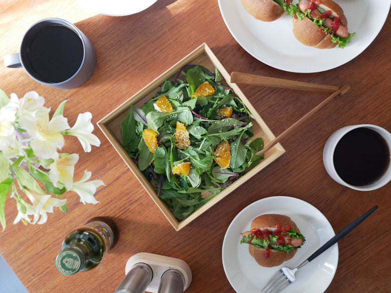 竹製の二段重箱に彩り豊かなサラダや野菜が盛り付けられた食卓の様子