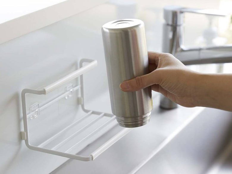 スチール製フィルムフックワイドジャグボトルホルダー Sがキッチンのカウンタートップに設置され、水筒や調理器具を整理整頓している様子