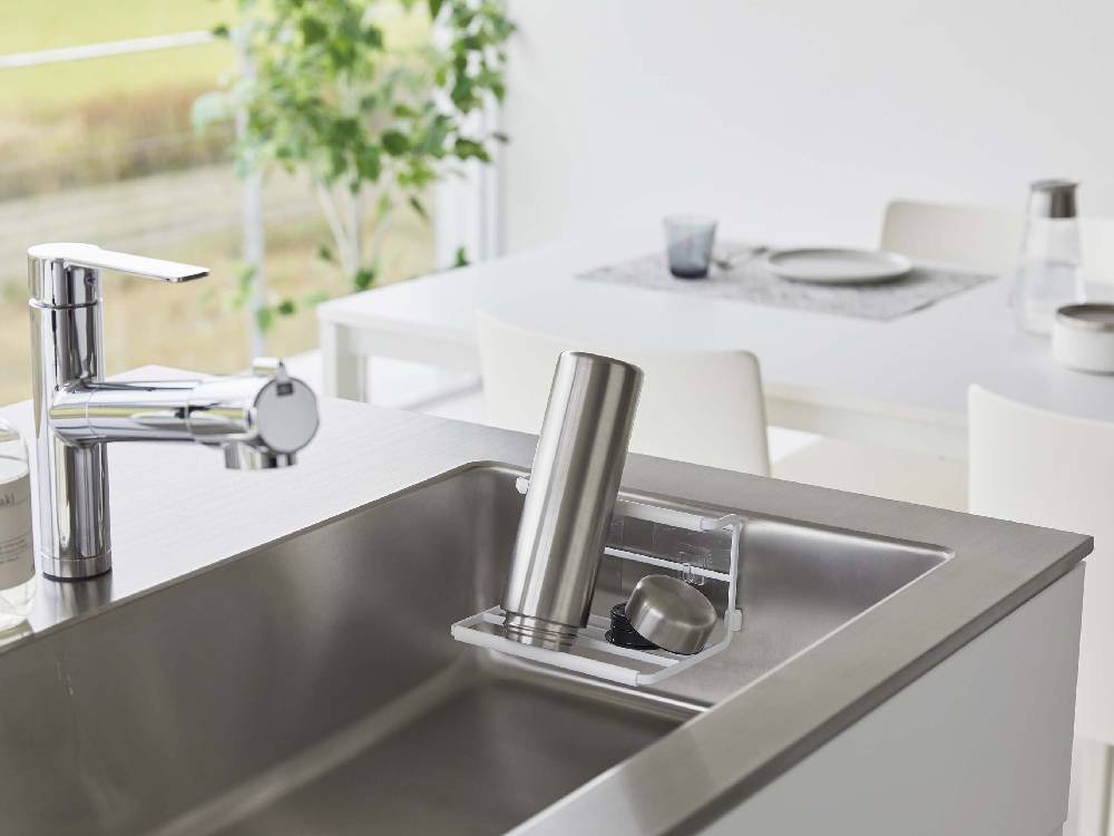 タワー フィルムフックワイドジャグボトルホルダー Sがキッチンシンクのカウンターに取り付けられている様子