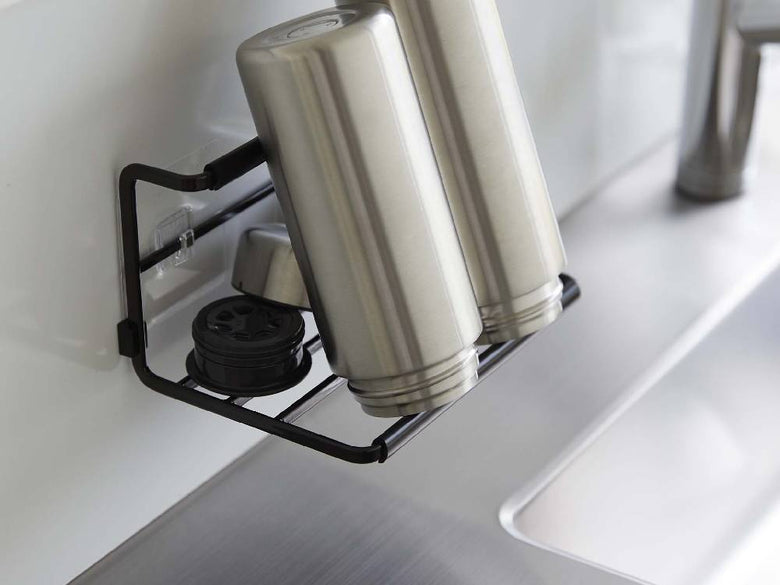 タワーのフィルムフックワイドジャグボトルホルダーSがキッチンのカウンタートップとシンク周辺に設置され、タンブラーやボトルが掛けられている様子。