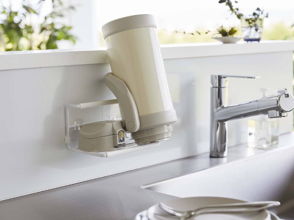 キッチンのシンクにタワーのフィルムフックワイドジャグボトルホルダーSが取り付けられ、ジャグボトルを収納している様子